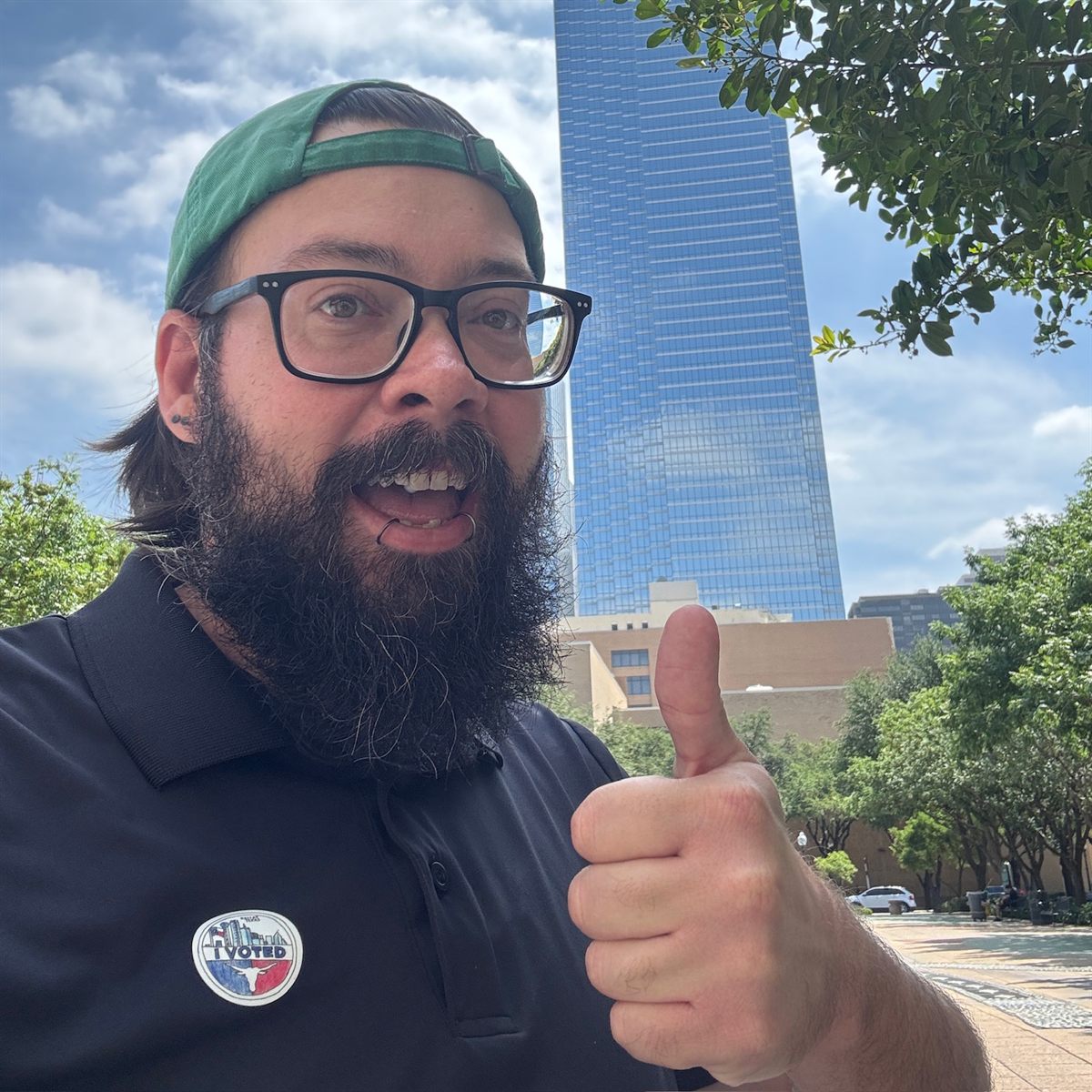 John T. Mallon giving a thumbs up in downtown Dallas, wearing an I Voted sticker